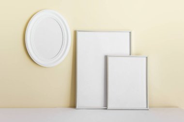 Ağaç çerçeveli maket şablonu - beyaz oval çerçeve, sarı duvarın arka planında A4 ve A3.