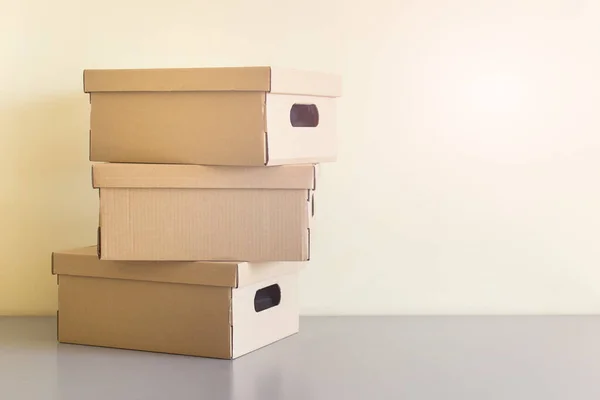 Three stacked carton boxes on gary table. Photo with copy blank space.