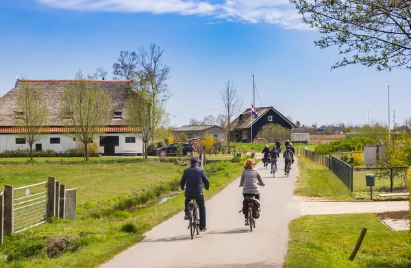 オランダのフリースラントの風景の中で自転車に乗る人々 — ストック写真