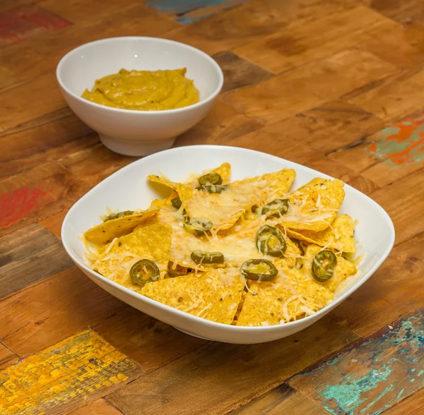 Nachos with cheese and jalapenos in a white bowl and fresh guaca — Stok fotoğraf