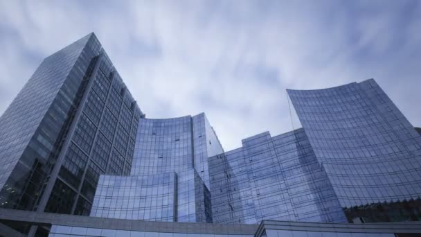 gratte-ciel en verre bleu avec des nuages passant par 