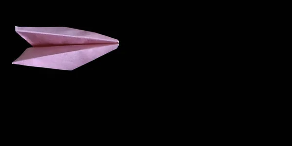 Siyah arkaplanda pembe kağıt uçak