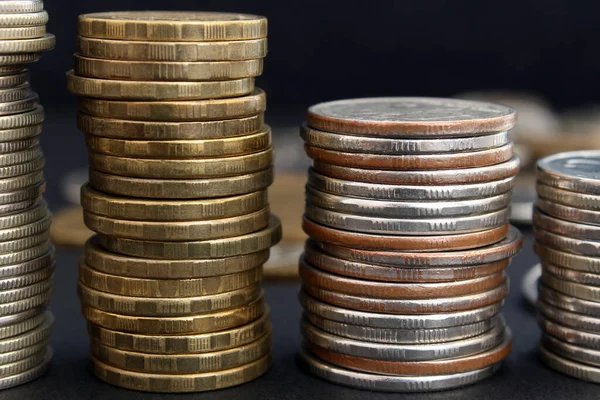 Bozuk para yığınları koyu bir arkaplanda kapanır