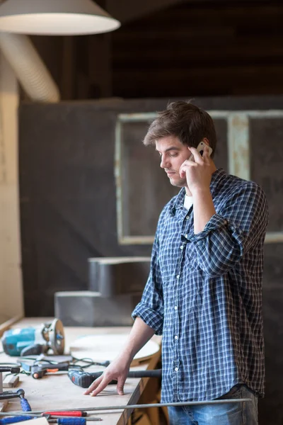 Male carpenter in carpentry shop on the phone,  man at work, lif