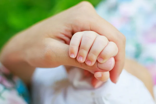 mother\'s hand holding baby\'s hand