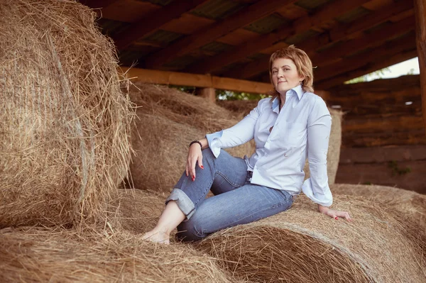 Woman over haystack in barn — Stock Photo, Image