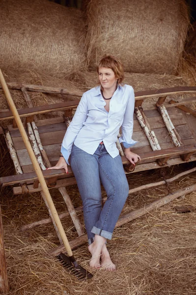Woman over haystack in barn — Stock Photo, Image