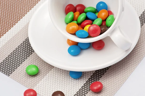 Красочные конфеты в белой чашке — стоковое фото