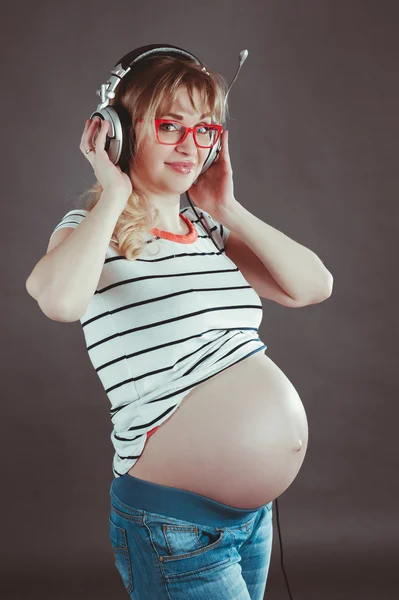 Gravid kvinna lyssna på musik i hörlurar — Stockfoto