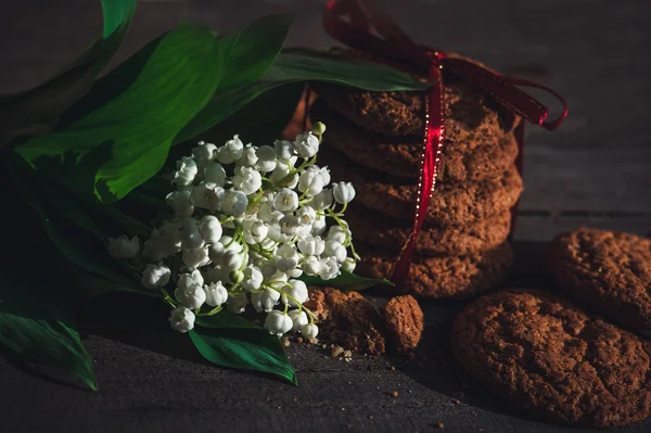 Yulaf ezmeli kurabiye ve çiçek açan çiçek — Stok fotoğraf