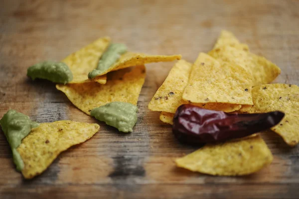 Zelfgemaakte guacamole met maïs chips bovenaanzicht op houten tafel — Stockfoto