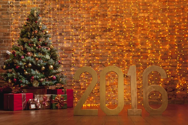 Letters '2016' and decorated Christmas tree on brick wall background — Stock Photo, Image