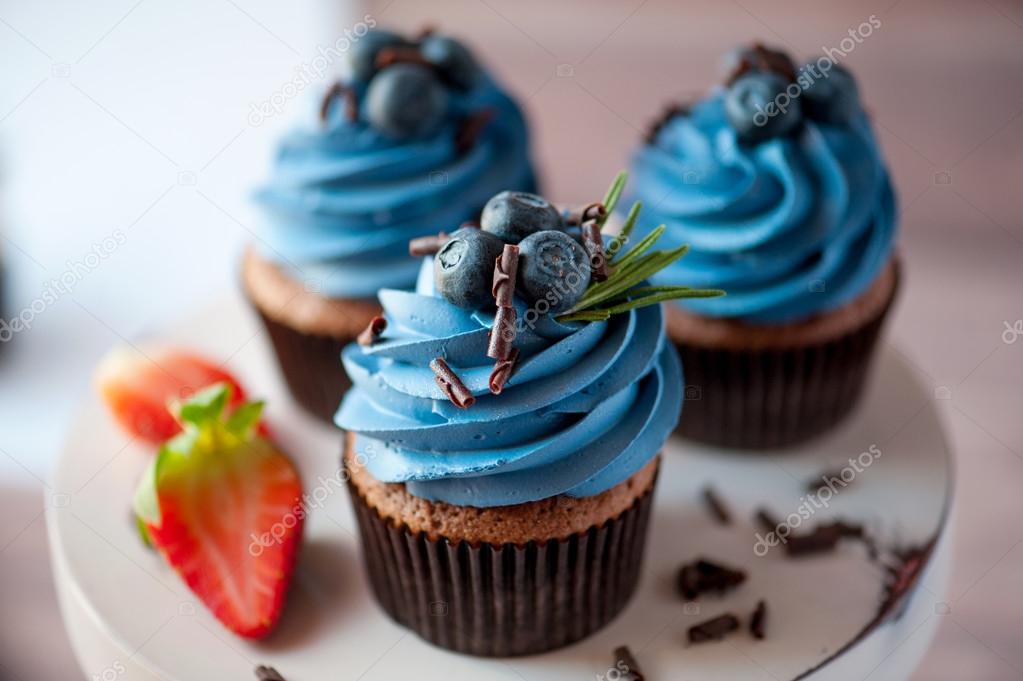 three cupcake with blueberry cream