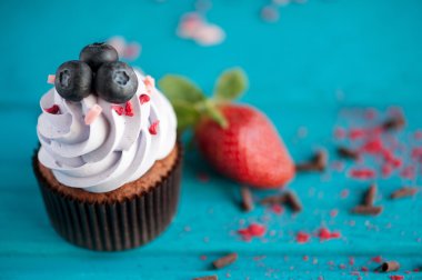 Mavi ahşap masa üzerinde yaz meyveleri ile cupcakes