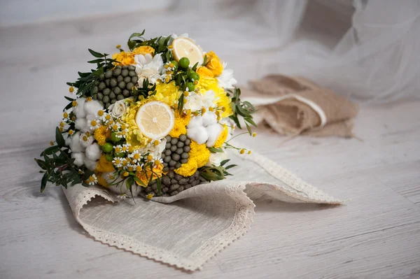 Wedding bouquet from cotton, lemon, chamomile on a green grass