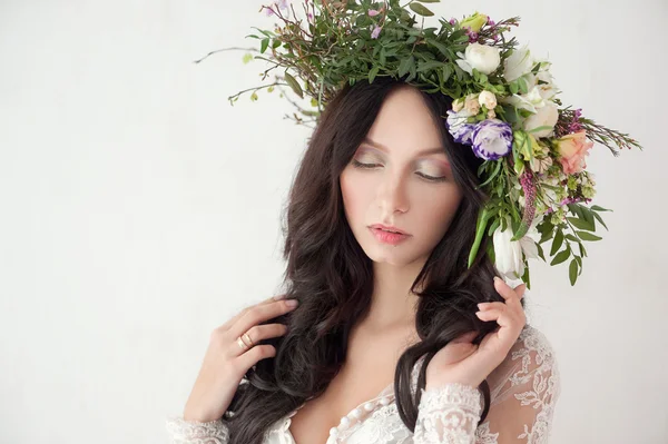 Mulher bonita com cabelo encaracolado, maquiagem e flores grinalda — Fotografia de Stock