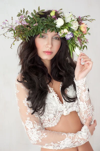 Krásná žena s kudrnatými vlasy, make-up a květiny věnec — Stock fotografie