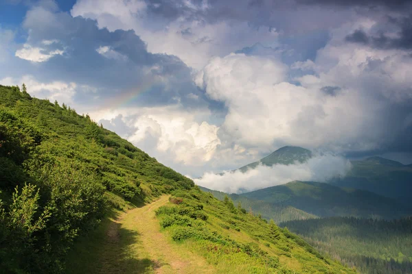 Rainbow after rain in mountains — Stock Photo, Image