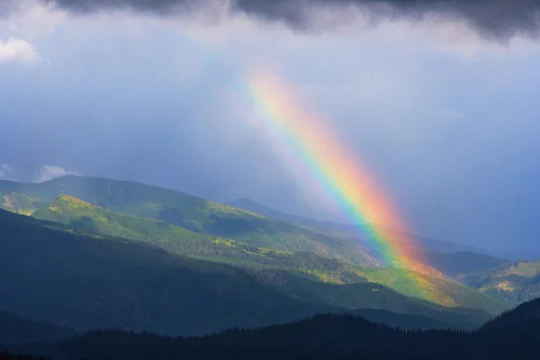 Rainbow after rain in mountains — Stock Photo, Image