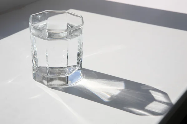 Un verre d'eau sur le rebord de la fenêtre — Photo