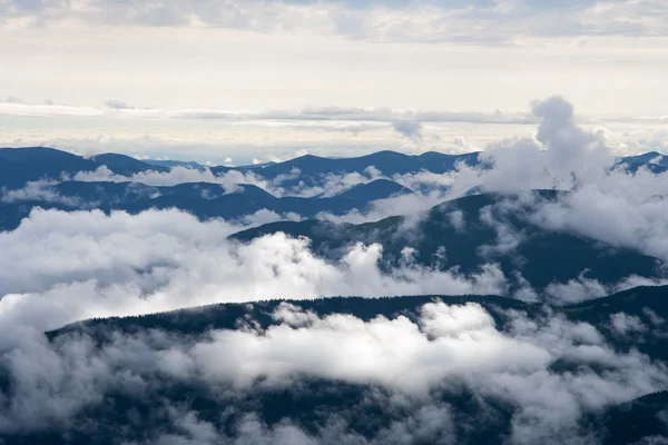 Nubes se elevan sobre montañas — Foto de Stock