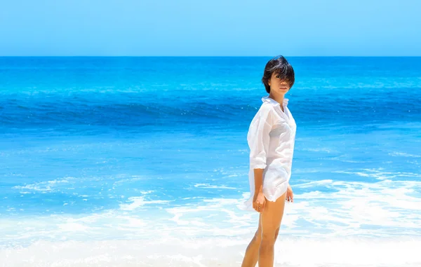 Азіатські дівчата в білій сорочці стоячи на пляжі проти моря — стокове фото