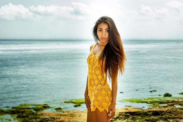 İnanılmaz güzel muhteşem Asya uzun saçlı kahverengi deri Bayan sarı yazlık elbise ayakta poz okyanus vibes Deniz Manzaralı günü yakalanan mavi taze gün — Stok fotoğraf