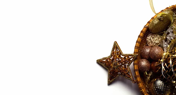 Güzel bir Noel geçmişi. Altın oyuncaklar, kurdeleler, süsler, beyaz arka planda izole edilmiş çelenkler. Selamlama, davetiyeler, web tasarımı, sosyal ağlar, sunumlar için.
