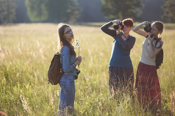 Ragazze con due macchine fotografiche e un mazzo di margherite — Foto Stock