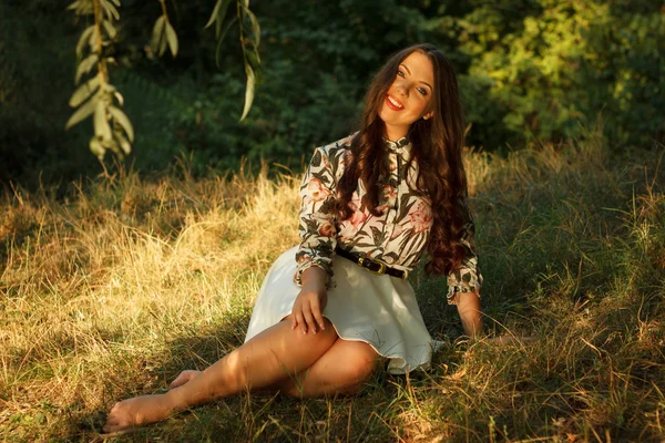 Fille s'assoit sur l'herbe et pose — Photo