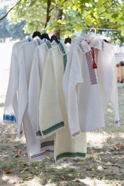Moldova tarzı açık havada beyaz keten erkek gömleklerinin sergilenmesi