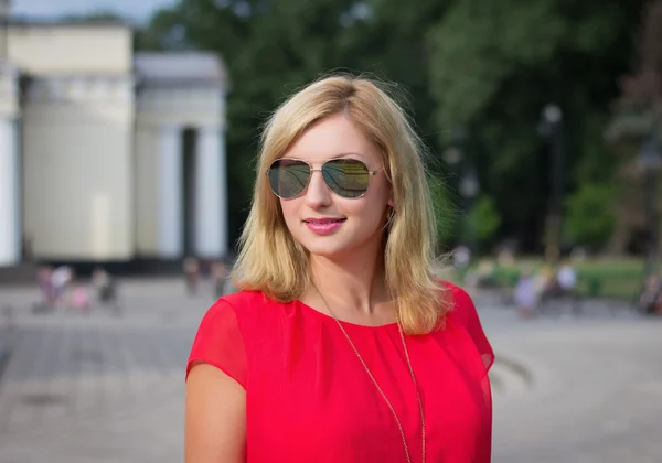 Femme blonde souriante aux lunettes de soleil — Photo