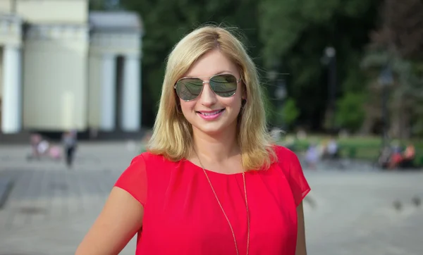 Heureuse femme blonde en lunettes de soleil — Photo
