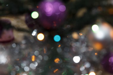 Renkli süsler ve ışıklar ile bulanık Noel ağacı süslemeleri neşeli bir atmosfer yaratıyor.