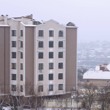 Modern bir apartmanı ve karı olan kentsel kış manzarası