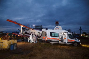 Tıbbi havacılık doktorları kovid 19 hastası olan bir hastayla ambulansa biniyor.