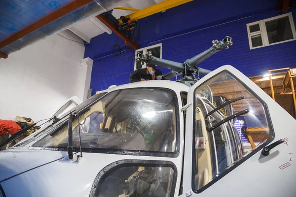 Rusia, Kirov. Mecánico reparando un helicóptero. Fijar el motor de un helicóptero — Foto de Stock