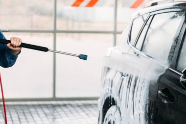 Kadın arabasını oto yıkama istasyonunda yıkıyor. Araba yıkama servisi.. 