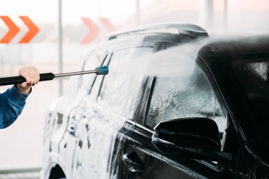 Kadın arabasını oto yıkama istasyonunda yıkıyor. Araba yıkama servisi.. 