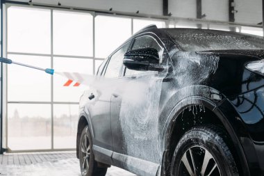 Kadın arabasını oto yıkama istasyonunda yıkıyor. Araba yıkama servisi.. 