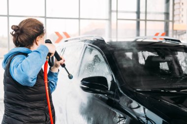 Kadın arabasını oto yıkama istasyonunda yıkıyor. Araba yıkama servisi.. 