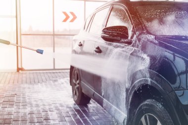 Kadın arabasını oto yıkama istasyonunda yıkıyor. Araba yıkama servisi.. 
