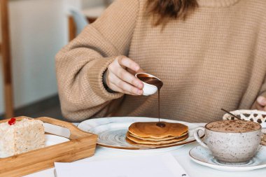 Kız bir kafede çikolatalı gözleme dolduruyor..