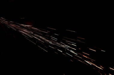 Karanlıkta parlayan kıvılcımlar. Koyu arkaplanda yangın kıvılcımları