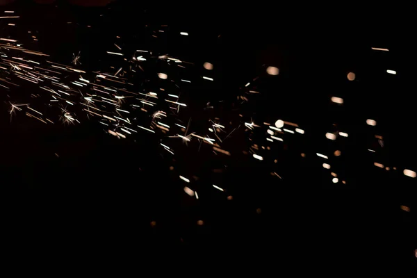 Glühender Funken im Dunkeln Feuerfunken auf dunklem Hintergrund lizenzfreie Stockfotos
