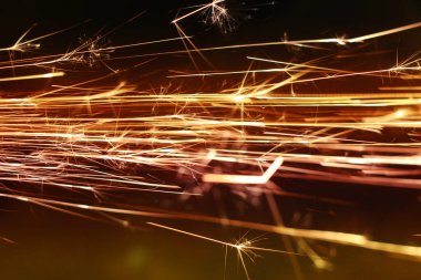 Karanlıkta parlayan kıvılcımlar. Koyu arkaplanda yangın kıvılcımları