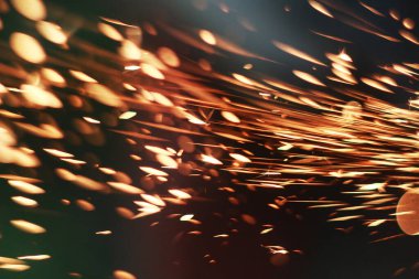 Karanlıkta parlayan kıvılcımlar. Koyu arkaplanda yangın kıvılcımları