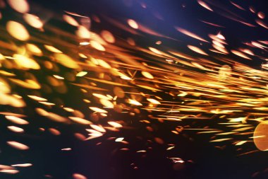 Karanlıkta parlayan kıvılcımlar. Koyu arkaplanda yangın kıvılcımları