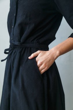 Güzel, siyah kadife bir elbise ve yakın plan bir kız. Elini kemere koy.