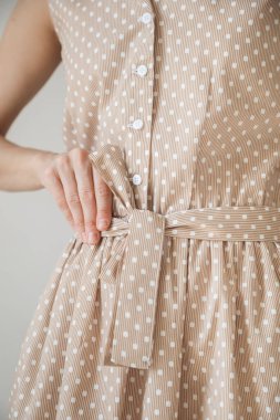 Güzel açık kahverengi, yakın plan bir kızın üzerinde benekler var. Elini kemere koy. 